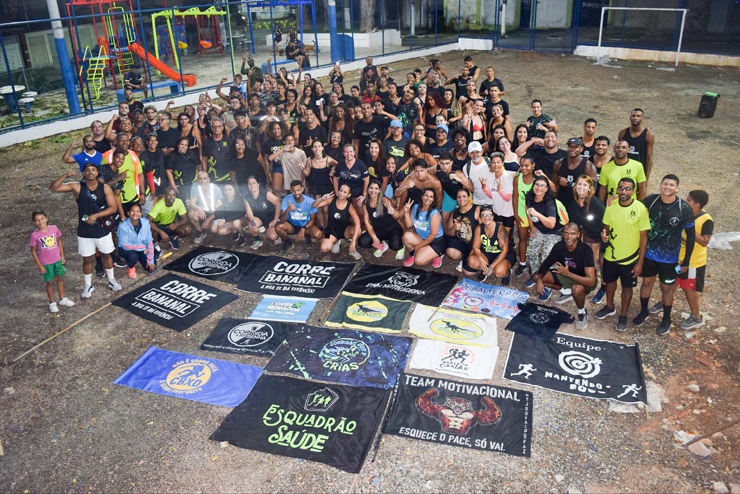Equipes de corrida reunidas com suas bandeiras em uma quadra