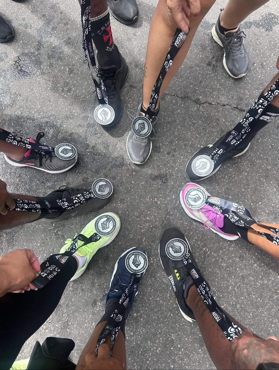 Tênis de corredores em roda, com suas medalhas